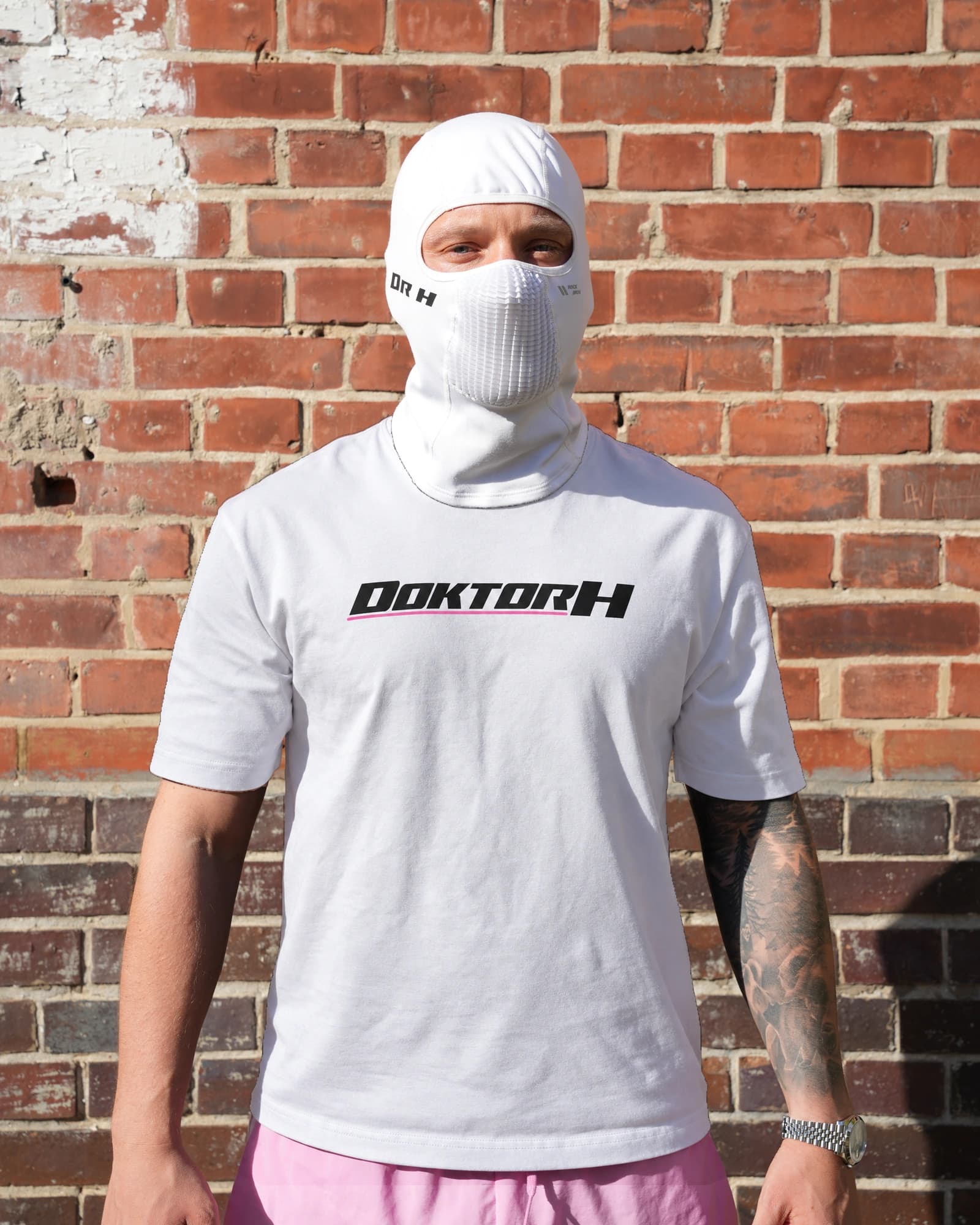 Weißes DOKTOR-H-Shirt mit schwarzem Frontdruck und pinkem Unterstrich, getragen